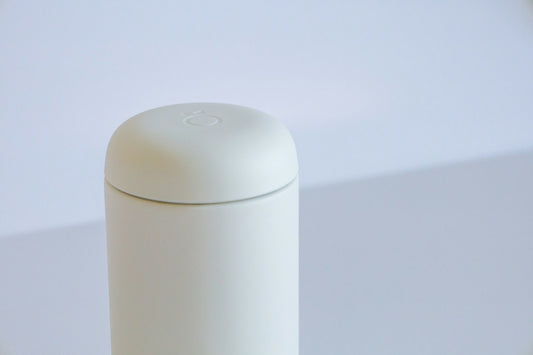 A minimal white cylindrical container on a pale gray surface